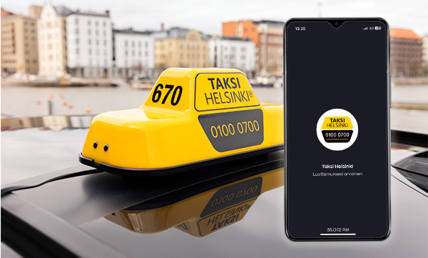 Taksi Helsingin keltainen kattovalo ja älypuhelin, jonka näytöllä näkyy Taksi Helsinki -sovellus